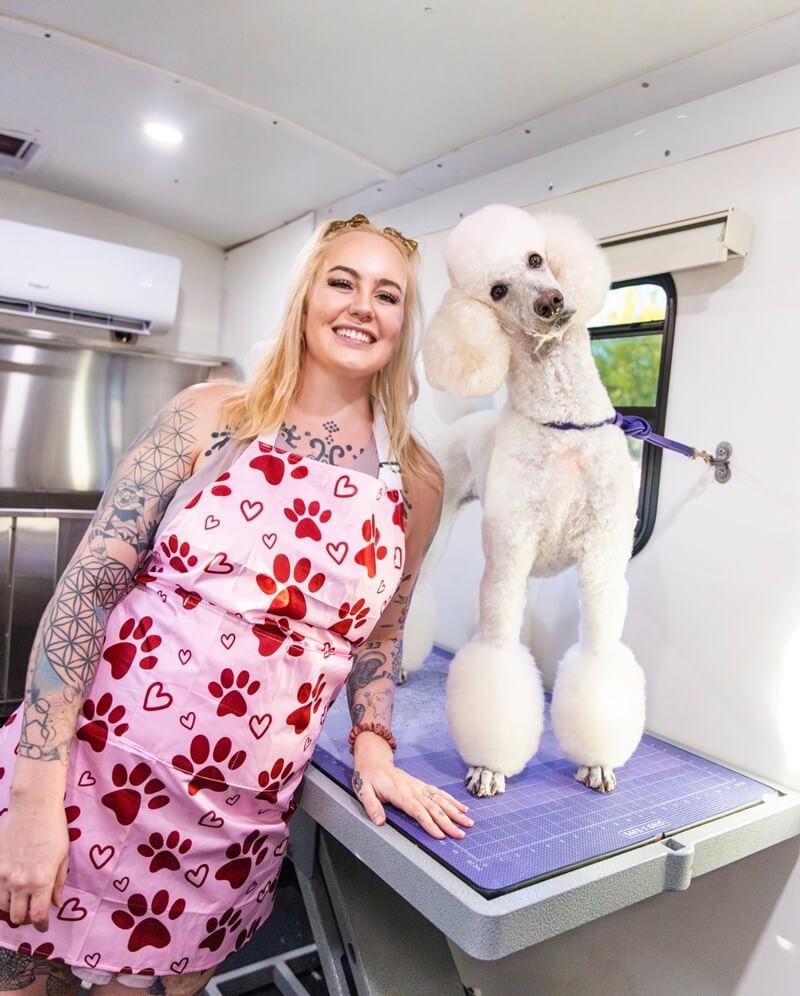 Hailey smiling next to a Poodle